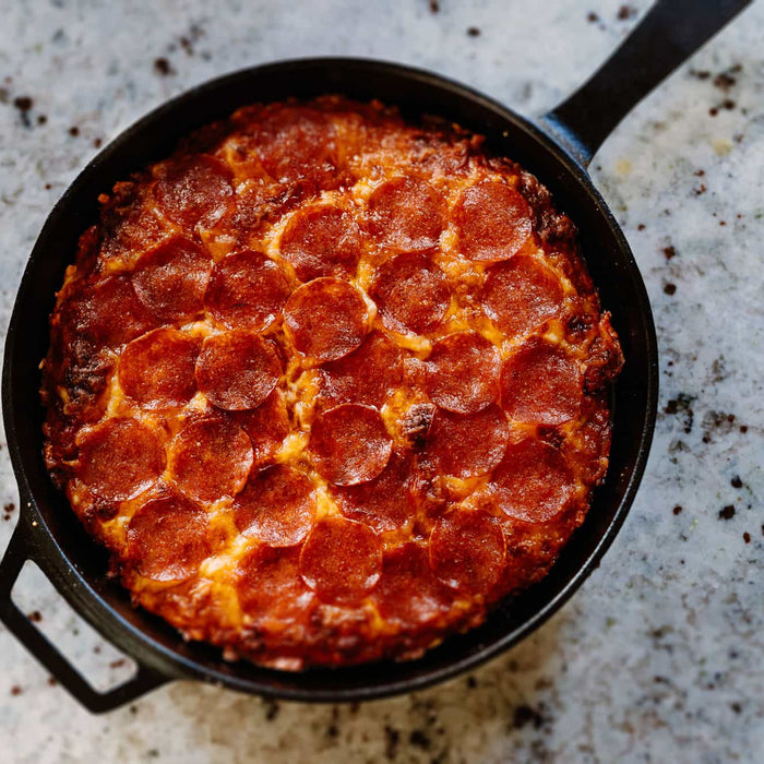 An easy skillet pizza topped with pepperoni and cheese baked in a cast iron pan.