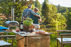 Couple overlooking lake with Fyra picnic setup