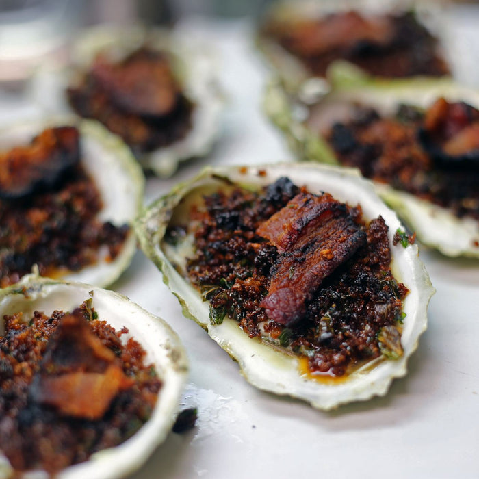 Bourbon Bacon Oysters Rockefeller served on a white plate