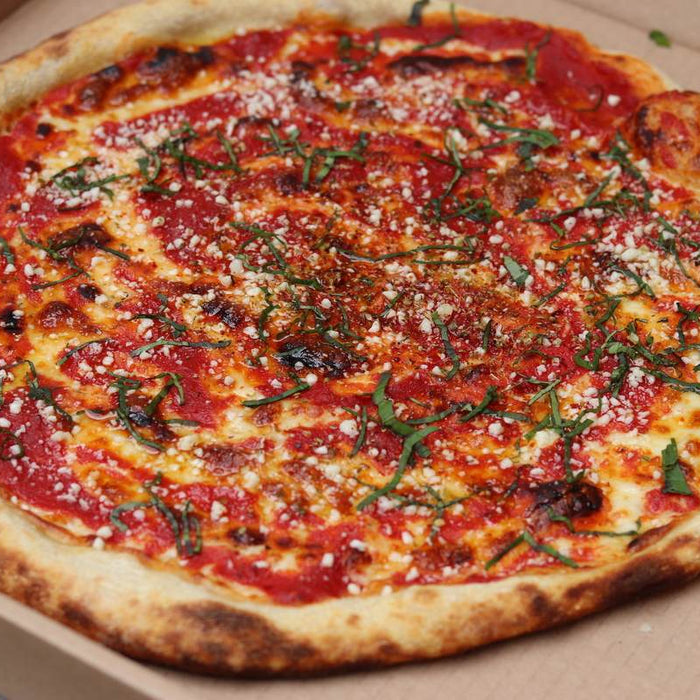 A New Jersey tomato pie in a cardboard pizza box made using a tomato pie recipe