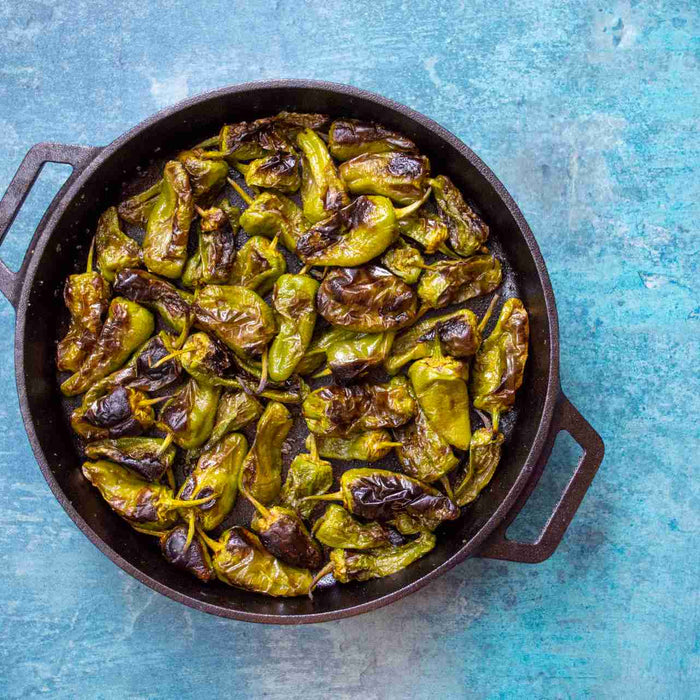 Blistered Padrón Peppers cooked in a Ooni Cast Iron Skillet
