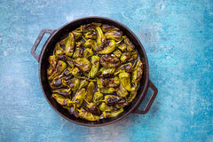 Blistered Padrón Peppers cooked in a Ooni Cast Iron Skillet