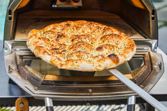 A Ramazan Pidesi being taken out of an Ooni Karu 16 pizza oven