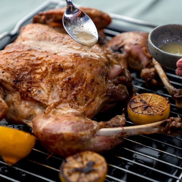 Spatchcocked Turkey on a grill surrounded by lemons and made using a spatchcook turkey recipe