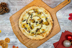 Crispy Roast Potato and Truffle Pizza with Brie and Sage on a bamboo pizza peel