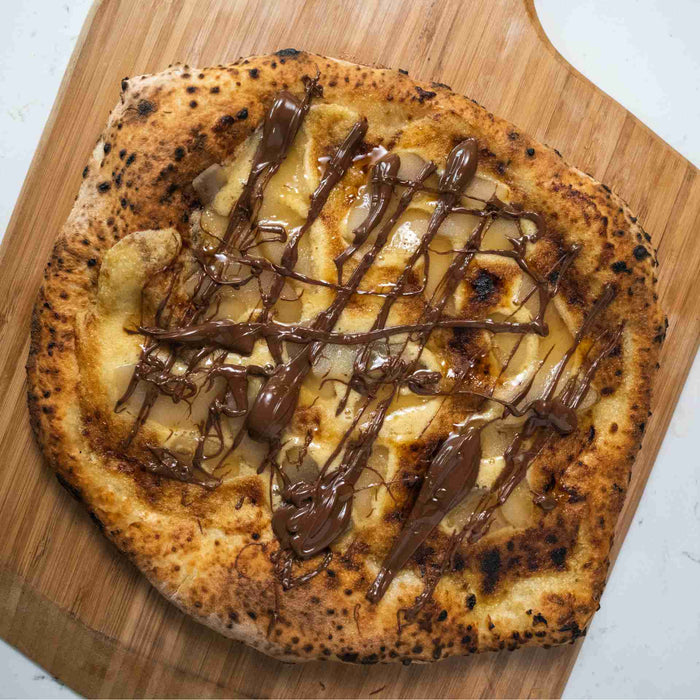 Nutella, Frangipane and Poached Pear Pizza on a wooden pizza peel