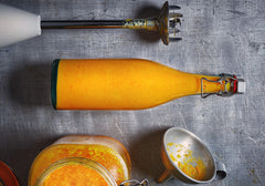 Sour yellow tomato fermented sauce in a glass bottle on a countertop