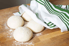 dough balls on a wooden counter top