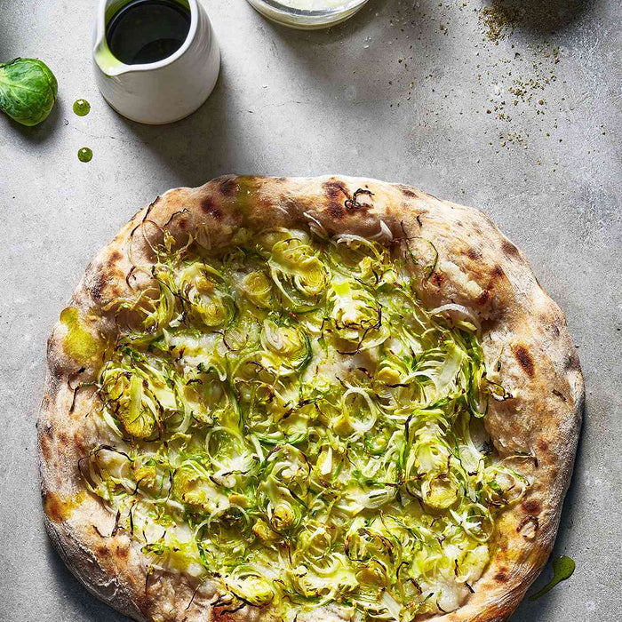 Jerusalem Artichoke and Brussels Sprout Pizza with Garlic and Herb Oil on a countertop
