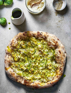 Jerusalem Artichoke and Brussels Sprout Pizza with Garlic and Herb Oil on a countertop