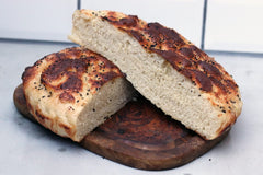 Turkish pide bread on a wooden chopping board made using a Turkish Pide recipe