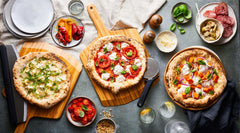 variety of pizzas with peels and cutter wheels