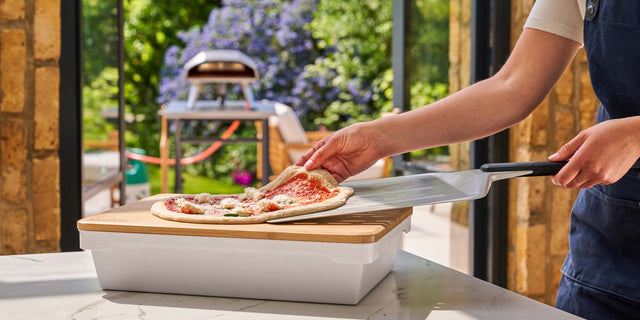 Pizza being slid onto pizza peel