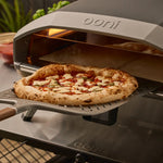 Ooni pizza oven with a freshly baked pizza on a aluminum signature pizza peel.