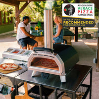 Ooni Karu 16 Pizza Oven with pizza cooking inside on top of large modular table