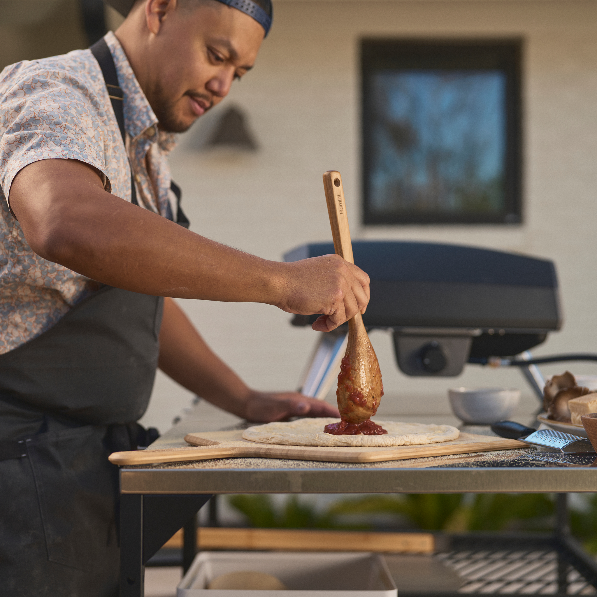 man preparing pizza in front of Koda 2 Pizza oven. 
