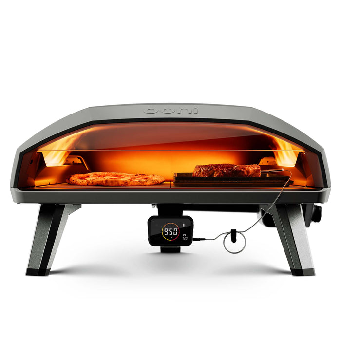 Ooni Koda 2 Max outdoor pizza oven face on baking a pizza and some meat in a griddle pan. | Click this image to open up the product gallery modal. The product gallery modal allows the images to be zoomed in on.